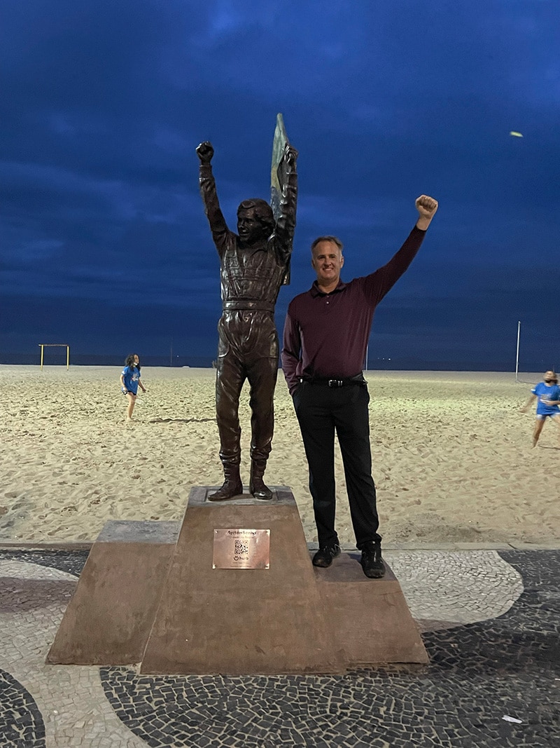 Dennis Hernandez standing with Ayrton Senna statue