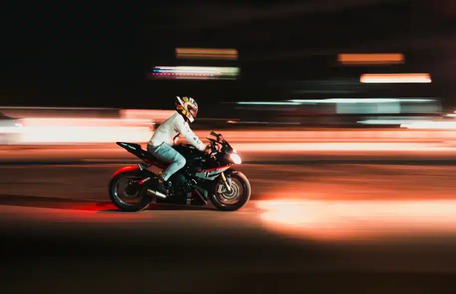 Motorcyclist riding at night, illustrating how motorcycle lighting failures can reduce visibility and increase accident risks.