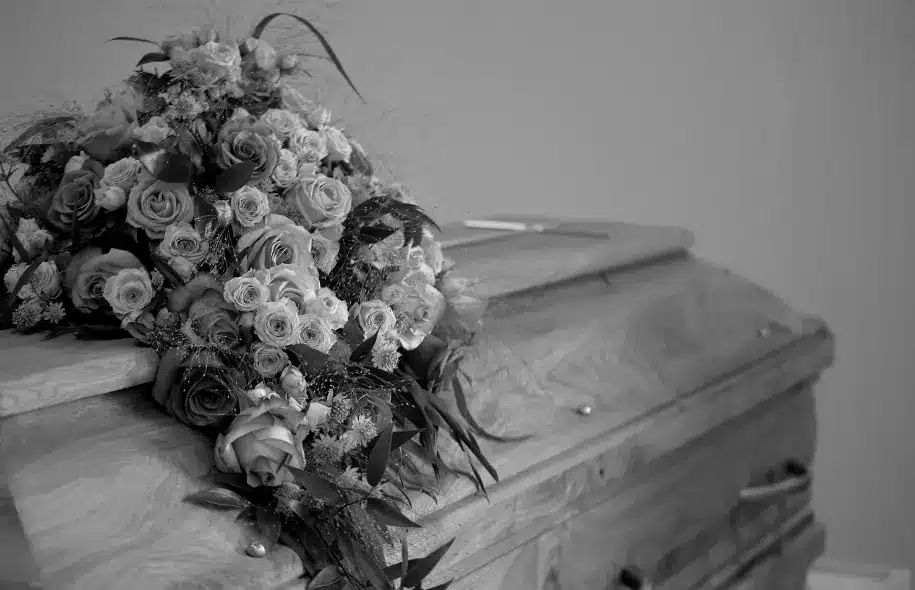 Casket covered with flowers, representing wrongful death claims and compensation available to eligible surviving family members.