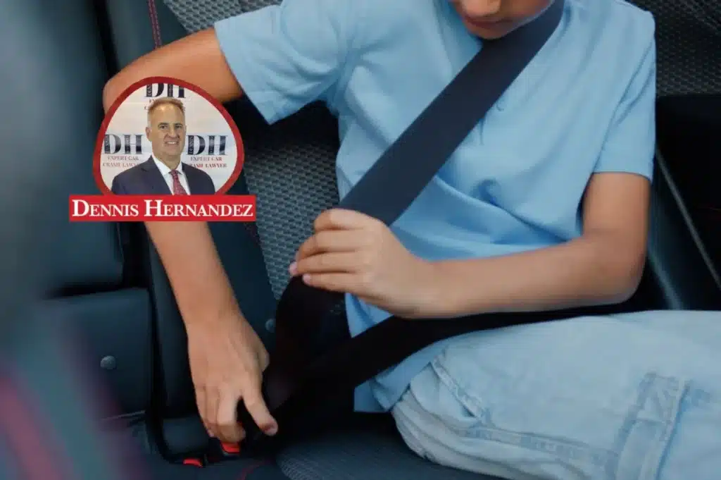 Child sitting in a vehicle and fastening a seatbelt, with the Dennis Hernandez Injury Attorneys logo overlay.