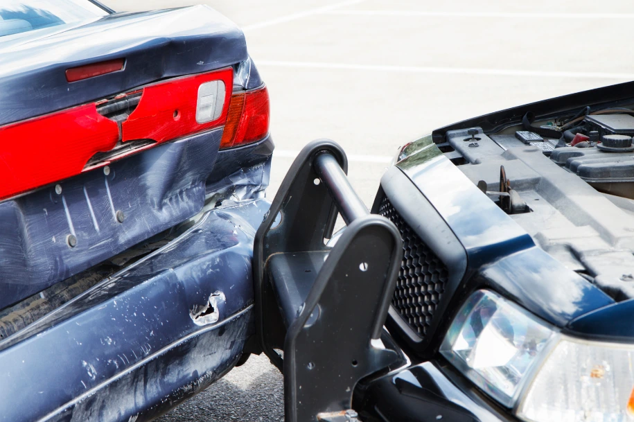 Rear end car collision showing damaged bumper and impact between two vehicles.