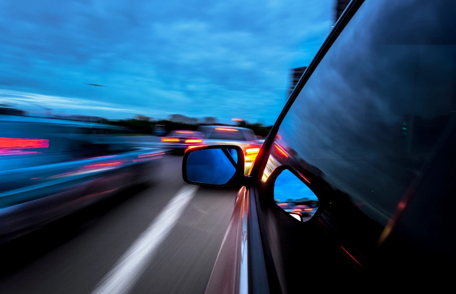 View from inside a moving car showing traffic blur and brake lights, illustrating the risks of high-speed driving and car accidents.