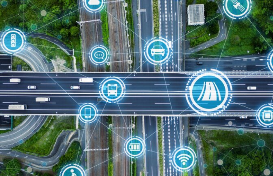 Aerial view of a smart highway with various technology icons such as Wi-Fi, car, bus, and mobile phone, symbolizing connected and intelligent road systems.