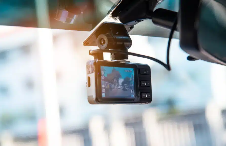 Dashboard camera mounted inside a vehicle, recording the road ahead through the windshield.