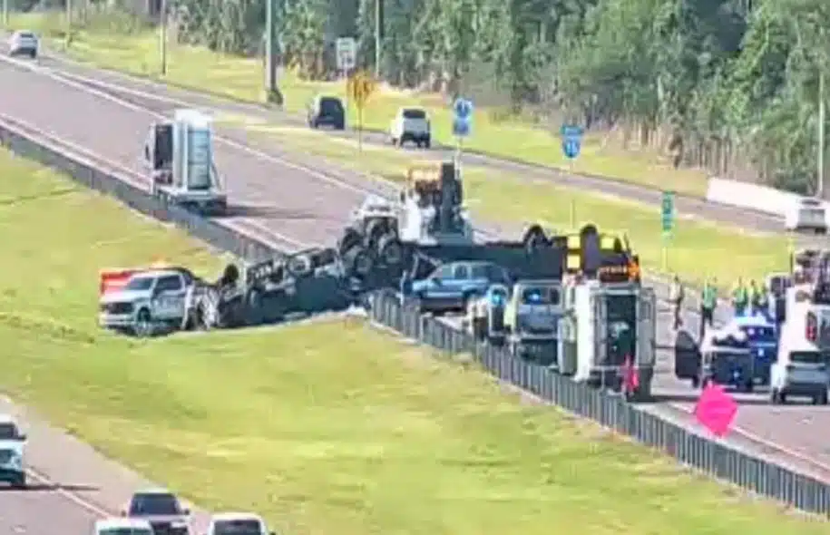 Serious highway accident involving a truck and multiple vehicles with emergency responders on scene.