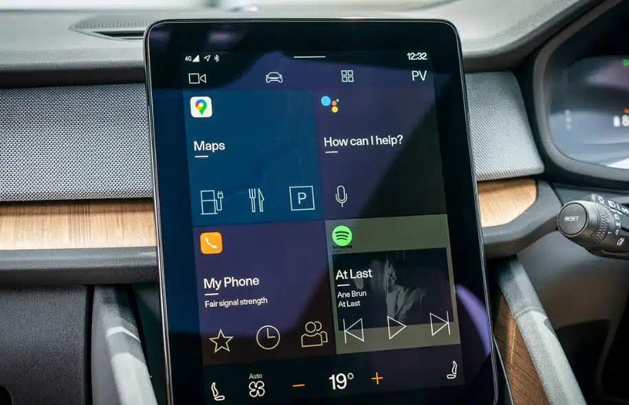 Person removing a tire from a car while changing a flat on the roadside.