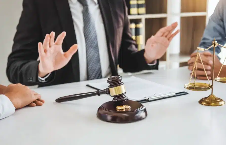 Attorney gesturing during a legal negotiation with gavel and scales on the table.