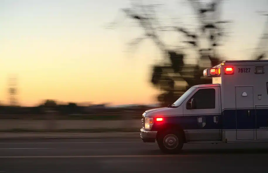 Ambulance driving with flashing lights at high speed during emergency response.