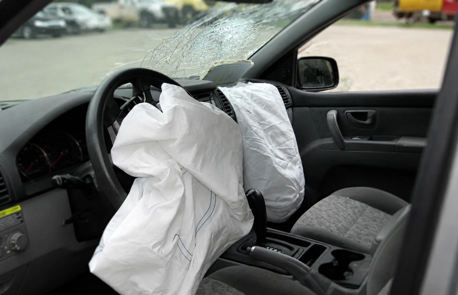 Deployed driver and passenger airbags inside a damaged vehicle after a Florida car accident with a cracked windshield.
