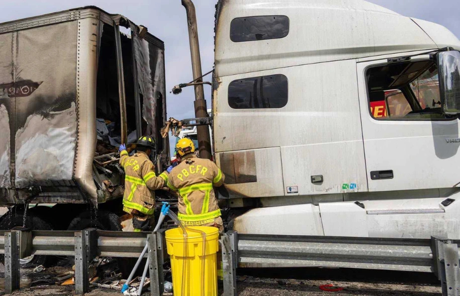 Palm Beach County Fire Rescue firefighters responding to a burned semi truck on Florida's Turnpike after a commercial vehicle fire.
