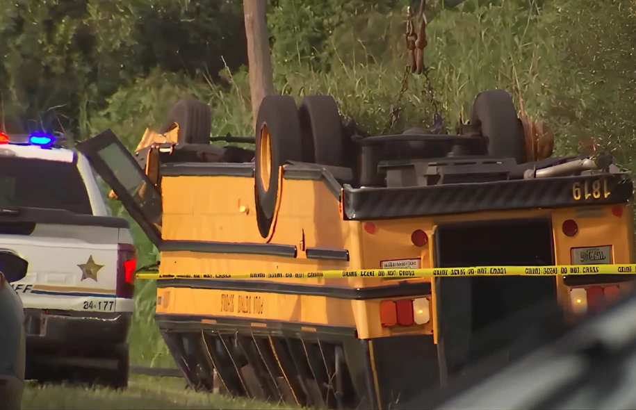 Overturned school bus at the scene of a fatal crash in Winter Haven, with a Polk County Sheriff’s Office vehicle nearby.