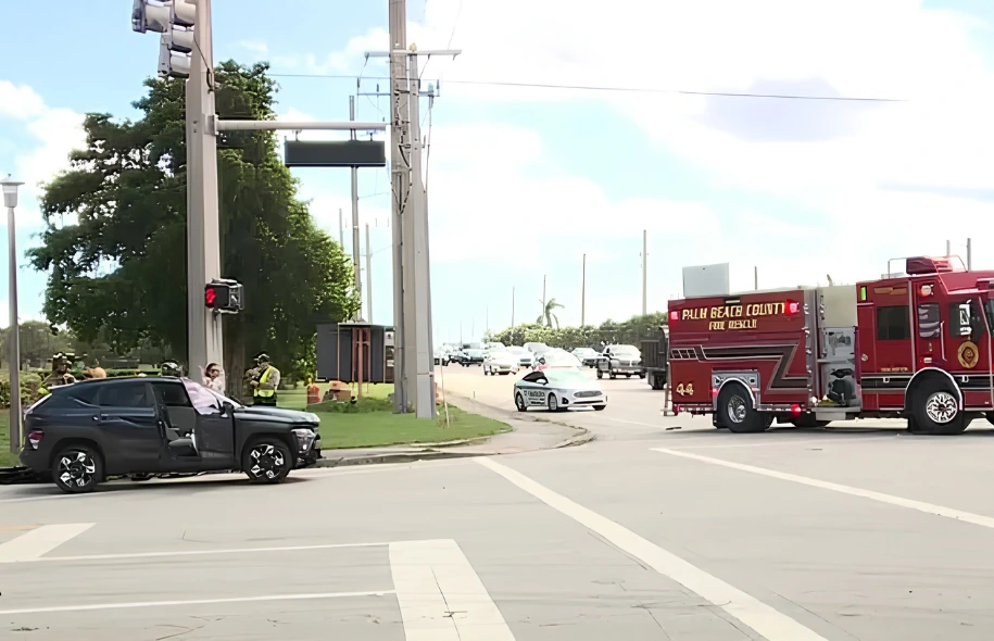 Damaged black pickup truck at a Boynton Beach intersection as Palm Beach County Fire Rescue and law enforcement respond.