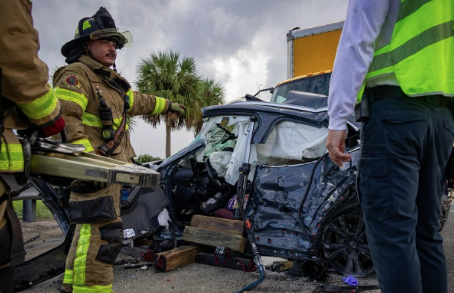 Emergency responders work beside a heavily damaged vehicle after a multi-vehicle crash on Florida’s Turnpike in Delray Beach.