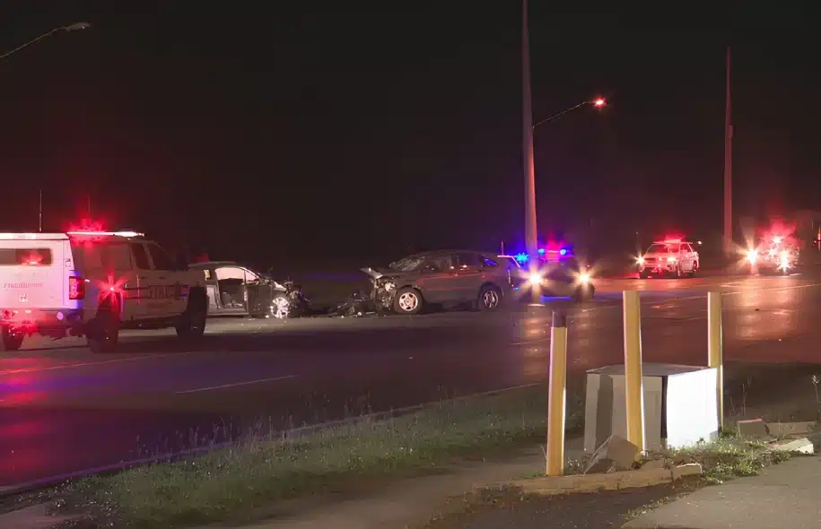 Police and emergency vehicles surround two damaged cars after a fatal nighttime head-on crash in Escambia County.